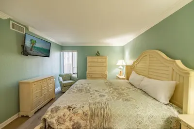 a bedroom with a large bed and a dresser at Edgewater 2-0602 'Beach Blessings' in Panama City Beach
