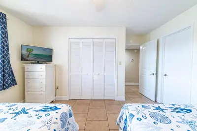 a bedroom with two beds and a closet at Edgewater Villa 3007 'Anchors Away' in Panama City Beach