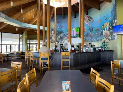 a man sitting at a bar in a restaurant at Edgewater Villa 3007 'Anchors Away' in Panama City Beach