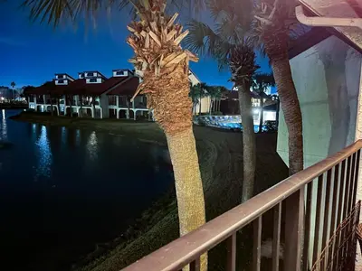 a palm tree on a balcony next to a body of water at Edgewater Villa 1510 'Beach & Golf' in Panama City Beach