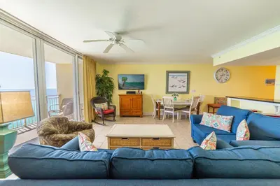 a living room with a blue couch and a table at Emerald Beach 2234 'Seas The Dream South' in Panama City Beach