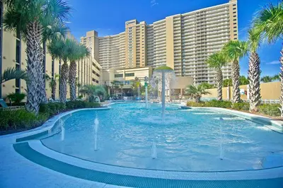 a fountain in front of a resort with palm trees at Emerald Beach 2234 'Seas The Dream South' in Panama City Beach