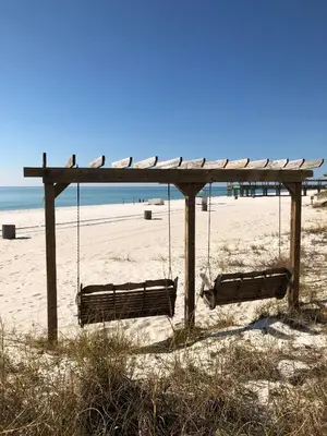 two swings on a beach with the ocean in the background at Sunbird 1104E 'Flamingo Palms' in Panama City Beach