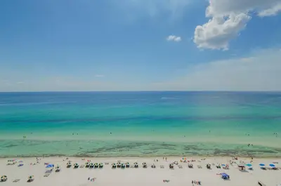 a group of people on a beach with the ocean at Sunbird 1104E 'Flamingo Palms' in Panama City Beach