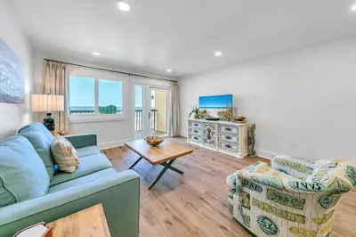 a living room with two couches and a table at Pinnacle Port B3-408-Emerald Pearl in Panama City Beach