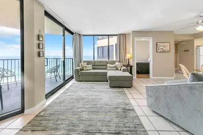 a living room with a couch and chairs and windows at Sunbird 807E in Panama City Beach