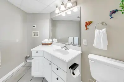 a white bathroom with a sink and a mirror at Sunbird 807E in Panama City Beach