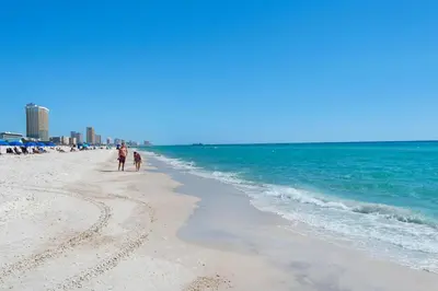 a man and a child walking on the beach at Sunbird 807E in Panama City Beach