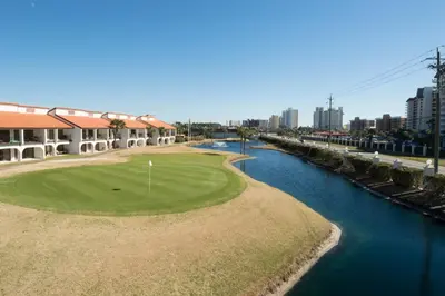 a golf course next to a river with buildings at Edgewater 1-0708 'Beach Happy' in Panama City Beach
