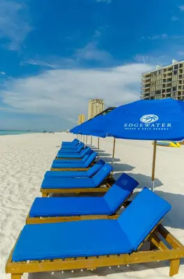 a row of blue beach chairs and umbrellas on the beach at Edgewater 1-0708 'Beach Happy' in Panama City Beach