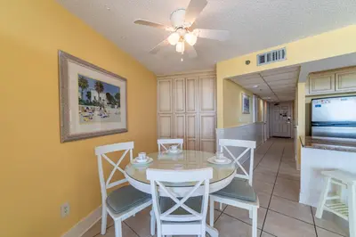 a dining room with a table and chairs and a ceiling fan at Edgewater 3-0905 'Gone Coastal' in Panama City Beach