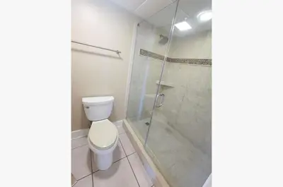 a bathroom with a toilet and a glass shower at Edgewater 3-0905 'Gone Coastal' in Panama City Beach