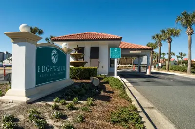 a sign in front of a building with palm trees at Edgewater 3-0905 'Gone Coastal' in Panama City Beach