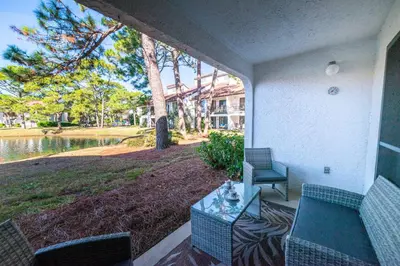 a patio with a table and chairs and a lake at Edgewater Villa 3005 'Paradise Palms' in Panama City Beach
