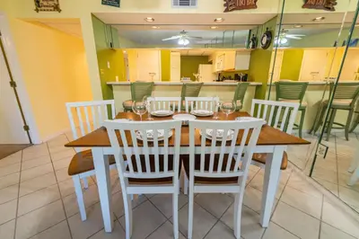 a dining room with a table and white chairs at Edgewater Villa 3005 'Paradise Palms' in Panama City Beach