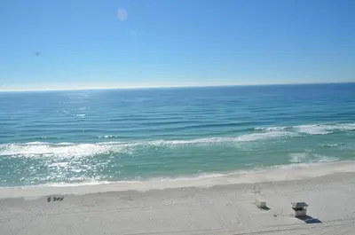 a view of the ocean with two chairs on the beach at Boardwalk 1409 'Emerald Ray' in Panama City Beach