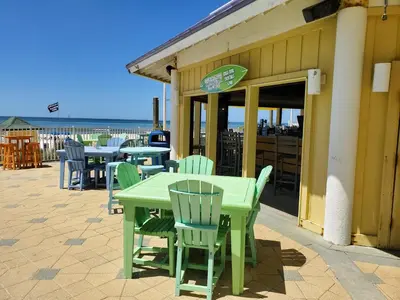 a green table and chairs sitting outside of a restaurant at Boardwalk 1409 'Emerald Ray' in Panama City Beach