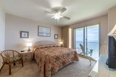 a bedroom with a bed and a balcony at Treasure Island 2004 'Pineapple Paradise' in Panama City Beach