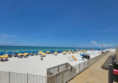 a beach with chairs and umbrellas and the ocean at Treasure Island 2004 'Pineapple Paradise' in Panama City Beach