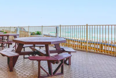 a picnic table and benches on a balcony overlooking the ocean at Treasure Island 2004 'Pineapple Paradise' in Panama City Beach
