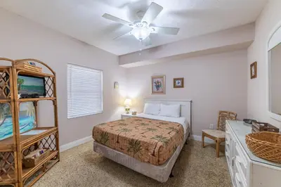 a bedroom with a bed and a ceiling fan at Treasure Island 2004 'Pineapple Paradise' in Panama City Beach