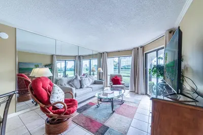 a living room with a couch and a tv at Edgewater Villa 1303 'Gone Gulf'N' in Panama City Beach