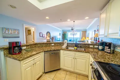 a kitchen with granite counter tops and a sink at Boardwalk 0810 'Endless Summer' in Panama City Beach
