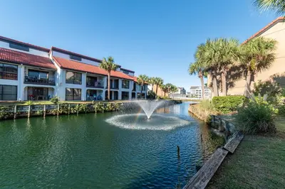 a fountain in a pond in front of a building at Edgewater Villa 2205 'Turtle Dunes' in Panama City Beach