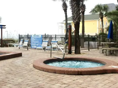 a small fountain in a patio with chairs and tables at Commodore 1309 'Paradise Pass' in Panama City Beach