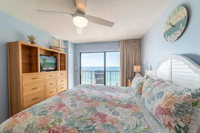 a bedroom with a bed with a clock on the wall at Commodore 1309 'Paradise Pass' in Panama City Beach