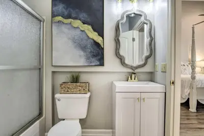 a bathroom with a toilet and a sink and a mirror at Cozy Beach Condo in Panama City Beach