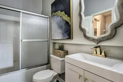 a bathroom with a toilet and a sink and a mirror at Cozy Beach Condo in Panama City Beach