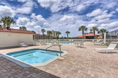 a swimming pool with lounge chairs and a resort at Cozy Beach Condo in Panama City Beach