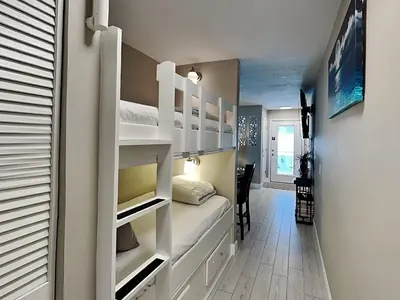 a small room with bunk beds and a hallway at Horizon South #57-203 in Panama City Beach