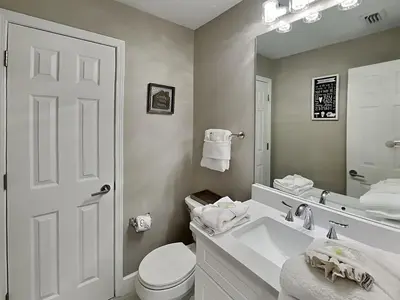 a bathroom with a toilet and a sink and a mirror at Horizon South #57-203 in Panama City Beach