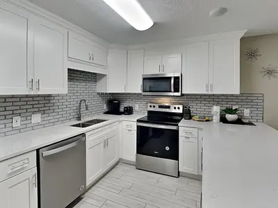 a kitchen with white cabinets and a stove top oven at Horizon South #57-203 in Panama City Beach