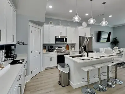 a kitchen with white cabinets and a white counter top at The Blue Pearls in Panama City Beach