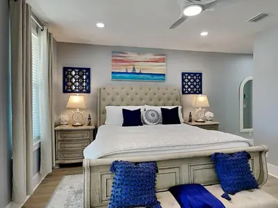 a bedroom with a large bed with blue pillows at The Blue Pearls in Panama City Beach
