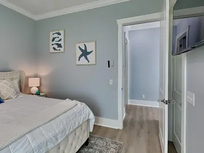 a bedroom with a bed and a sliding glass door at The Blue Pearls in Panama City Beach