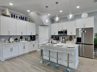 a large white kitchen with white cabinets and appliances at The Blue Pearls in Panama City Beach