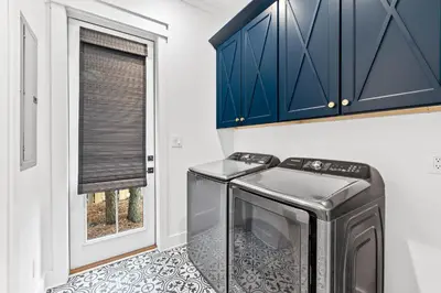 a kitchen with blue cabinets and a washer and dryer at 30Yay! by 30A Escapes in Watersound Beach