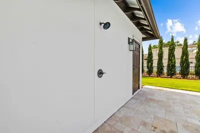 a white garage with a door and a yard at 30Yay! by 30A Escapes in Watersound Beach