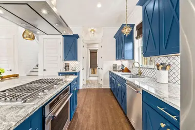 a blue kitchen with white walls and blue cabinets at 30Yay! by 30A Escapes in Watersound Beach