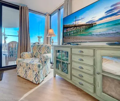 a living room with a tv and a chair at Sunbird Resort Ground Floor Gem with Ocean Views! Free Beach Chairs and Umbrella! by Dolce Vita Getaways PCB in Panama City Beach