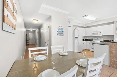 a kitchen and dining room with a table and chairs at Tidewater Beach Resort #1110 by Book That Condo in Panama City Beach