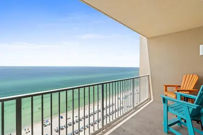 a balcony with two chairs and a view of the beach at Tidewater Beach Resort #1110 by Book That Condo in Panama City Beach