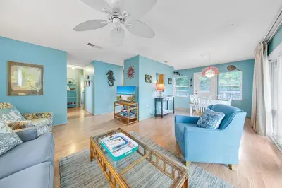 a living room with blue walls and a blue couch at Beach Haven by Emerald Coast Retreats in Panama City Beach