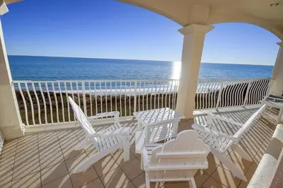 a porch with white chairs and a view of the ocean at Monterey C-201 in Seacrest