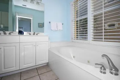 a white bathroom with a tub and a window at Monterey C-201 in Seacrest