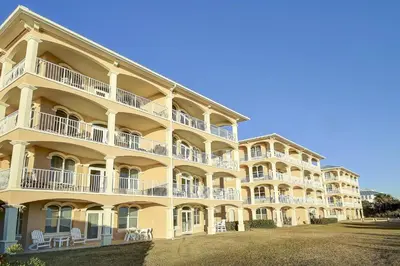 a large yellow building with white balconies and chairs at Monterey C-201 in Seacrest
